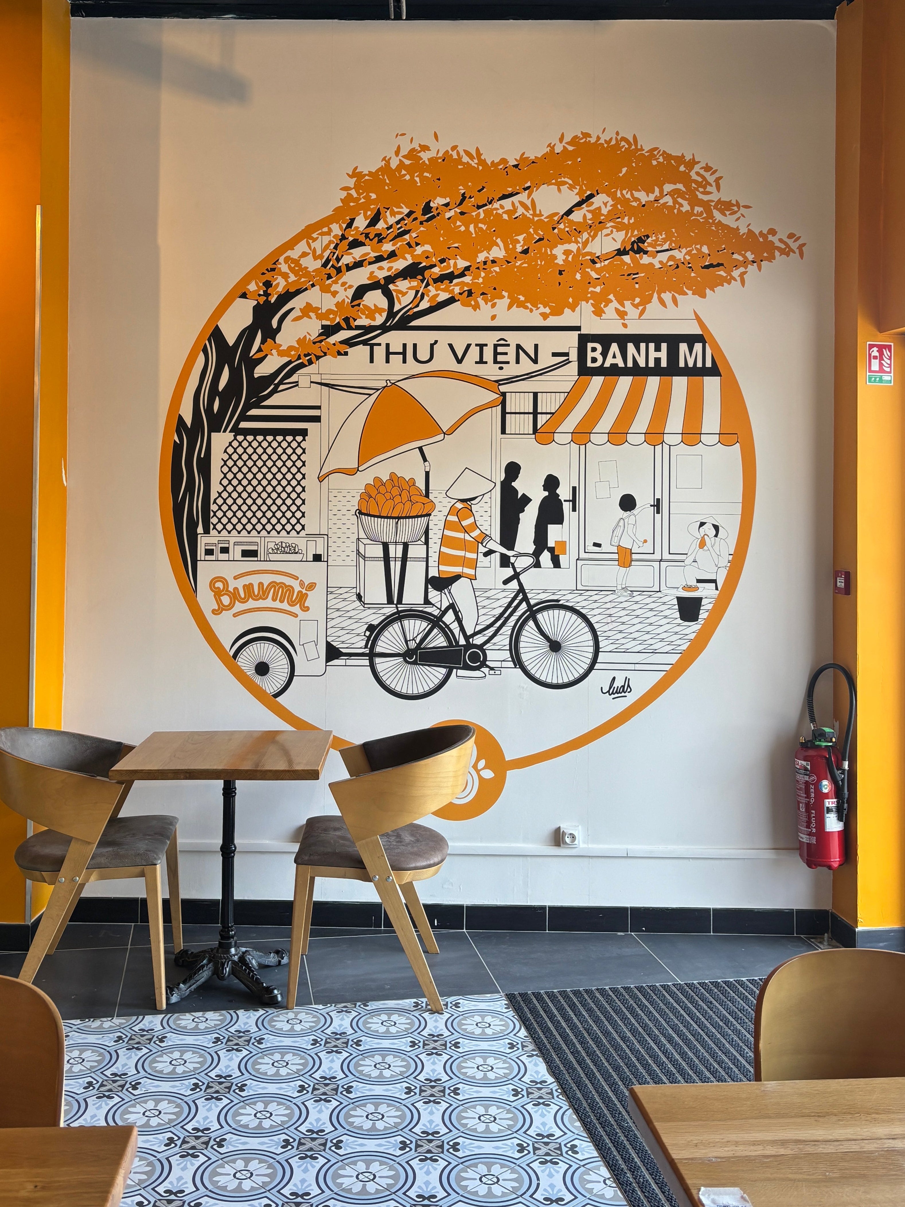 Papier peint à motifs géométriques dorés sur fond blanc, apportant une touche contemporaine et sophistiquée à la salle à manger.